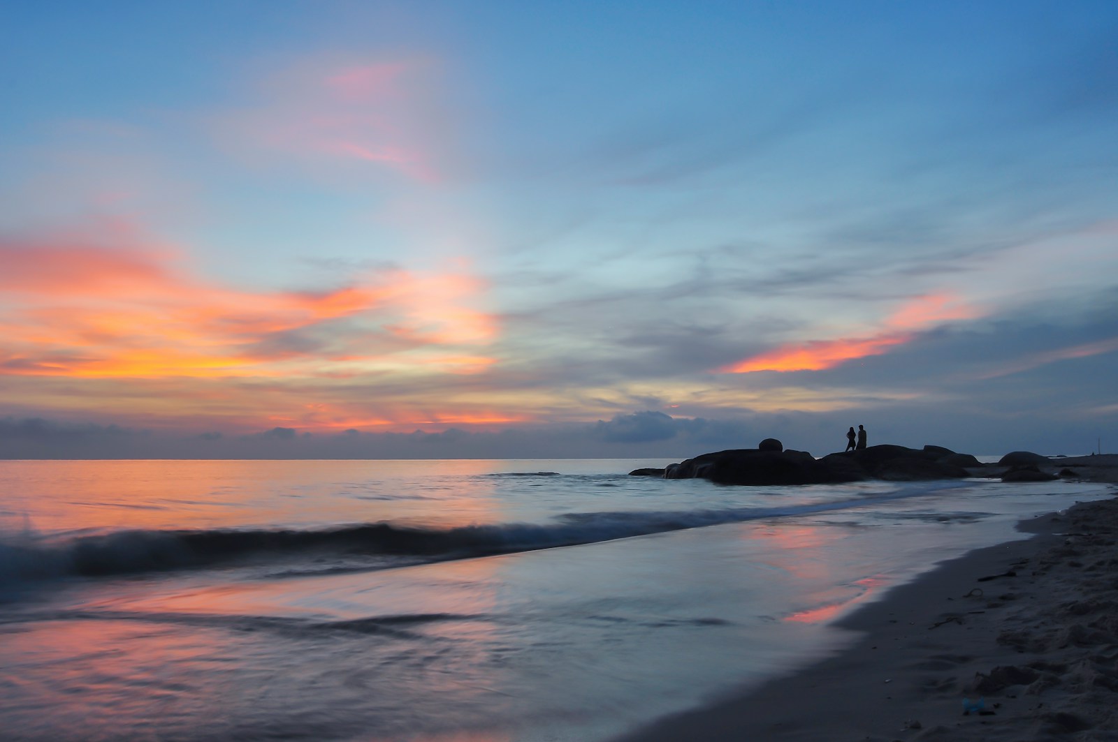 Ruhiger Sandstrand mit Felsen an der Küste von Hua Hin
